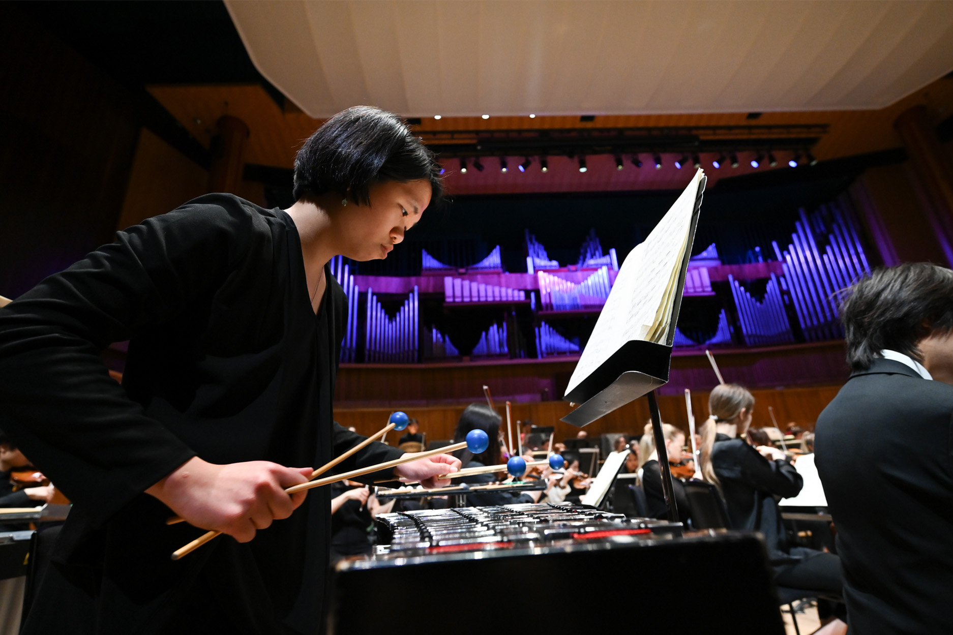 A female student playing the marimba in a rehearsal at the Southbank festival hall.